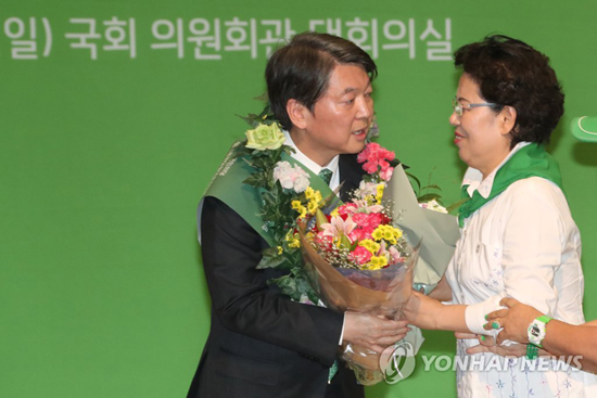 (서울=연합뉴스) 국민의당 안철수 새 대표가 27일 오후 국회 의원회관에서 열린 임시전국당원대표자대회에서 새 대표로 선출된 뒤 축하 꽃다발을 받고 있다.