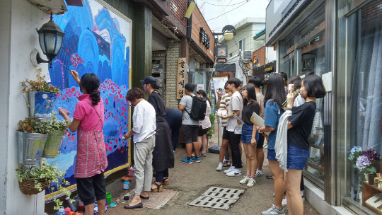골목여행지로 거듭난 경남 창원시 마산합포 창동에서 관광객들이 예술촌에 입점한 작가들의 작품활동을 감상하고 있다.  창원시 제공