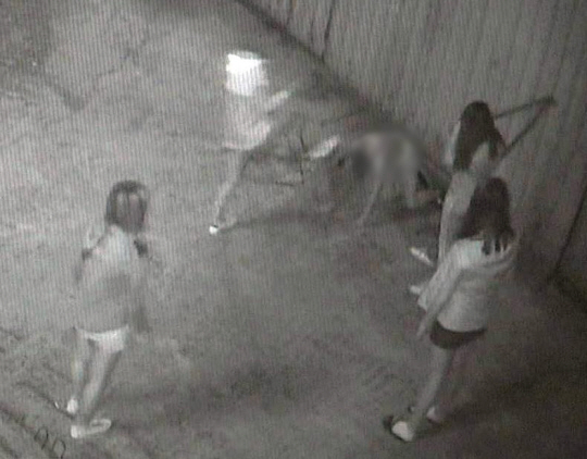 부산의 여중생들이 1일 이미 피투성이가 된 또래를 꿇어 앉혀놓고 계속 폭행하고 있다. 연합뉴스