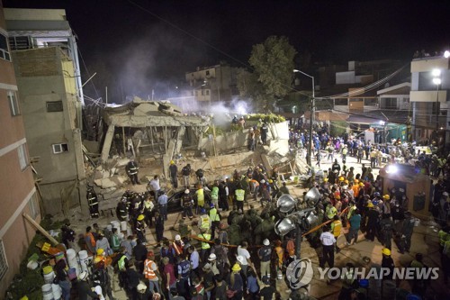 19일(현지시간) 멕시코의 수도 멕시코시티에서 발생한 지진으로 붕괴된 엔리케 레브사멘 초등학교에서 자원봉사자들과 구조자들이 생존자를 수색 중인 모습. [AP=연합뉴스]