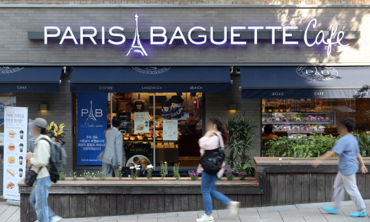 고용노동부가 파리바게뜨에 전국 3400여 개 가맹점에서 일하는 협력업체 제빵사 5300여 명을 직접 고용하라는 시정명령을 내린 가운데 21일 서울 시내 한 파리바게뜨 가맹점 앞으로 시민들이 지나가고 있다.  연합뉴스