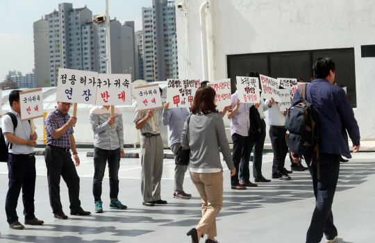 21일 ‘민자역사 국가귀속 관련 임차업체 간담회’가 열린 서울 영등포구 롯데백화점 영등포점 앞에서 상인들이 민자역사의 국가 귀속을 반대하는 피켓 시위를 벌이고 있다.  연합뉴스