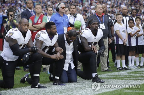 미국프로풋볼(NFL) 볼티모어 레이븐스 선수들이 24일(현지시간) 열린 잭슨빌 재규어스와 시합에 앞서 국가가 연주되자 그라운드에 무릎을 꿇고 항의하는 모습. (AP=연합뉴스)