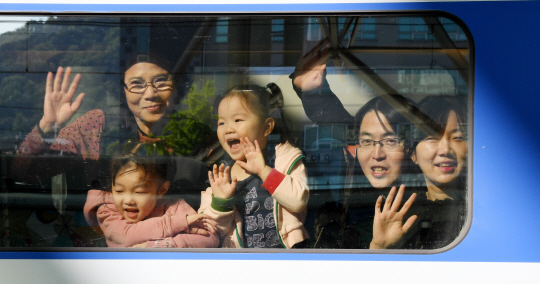 추석 연휴를 하루 앞둔 29일 서울역 승강장에서 귀향길에 오른 한 가족이 열차 창밖을 내다보며 즐거운 표정을 짓고 있다.