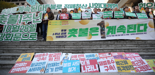 ‘박근혜정권퇴진 비상국민행동(퇴진행동)’ 참가단위 관계자들이 23일 오후 서울 종로구 세종문화회관 계단에서 ‘촛불은 계속된다’를 주제로 촛불 1주년 선포 기자회견을 하고 있다. 퇴진행동은 촛불 1주년 전날인 28일 1주년 촛불집회를 개최한다.  연합뉴스