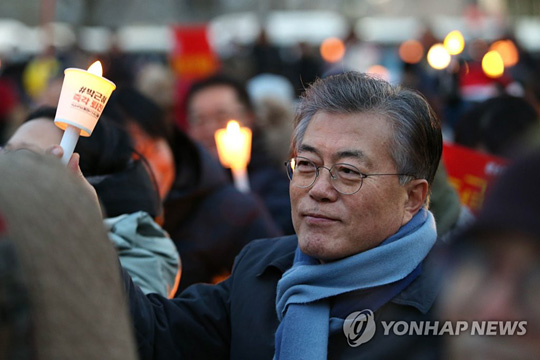 (서울=연합뉴스) 더불어민주당 문재인 전 대표가 성탄을 하루 앞둔 24일 오후 서울 광화문광장에서 열린 제9차 촛불집회에서 촛불을 들고 구호를 외치고 있다. 2016.12.24 [문재인 전 대표 제공=연합뉴스]