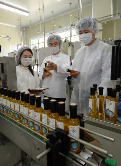 이은지(왼쪽부터) 안동지식재산센터 컨설턴트, 이민주 방깐F&B 대표, 권승민 안동지식재산센터 행정연구원이 최근 방깐F&B의 생산 라인에서 냉압착 기술을 통해 생산한 제품을 들고 이야기를 나누고 있다.
