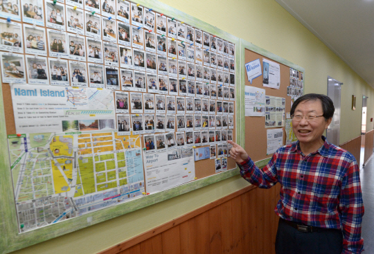 지난 10월 24일 오후 서울 중구 남산동에 있는 신도식 씨의 게스트하우스에서 신 씨가 그동안 방문한 여행객들이 남긴 사진에 대해 설명하고 있다.  김호웅 기자 diverkim@