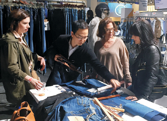 TCE코퍼레이션의 한 직원이 지난해 12월 미국 뉴욕 전시회 ‘킹핀 쇼’에서 자사의 데님을 외국인 관람객들에게 선보이고 있다.  TCE 제공