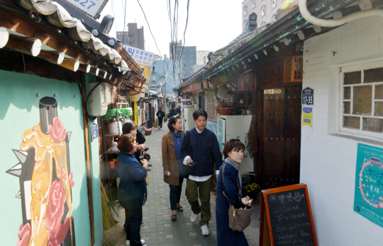 2일 서울 종로구 익선동 한옥마을을 찾은 관광객들이 카페·레스토랑 등으로 개조된 다채로운 한옥들을 구경하고 있다.