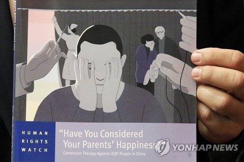 15일(현지시간) 홍콩에서 휴먼라이츠워치(HRW)의 보리스 디트리히 간사가 동성애 치료를 받은 중국 내 동성애자 17명을 인터뷰한 결과를 담은 보고서를 들고 있다. [AP=연합뉴스 자료사진]