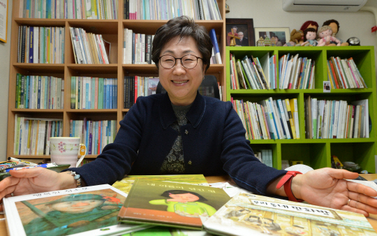 ‘그림책 전도사’로 살아가는 유경 어르신사랑연구모임 대표가 평소 교재로 활용하는 그림책을 자랑하듯 펼쳐놓고 환히 웃음짓고 있다.  김동훈 기자 dhk@