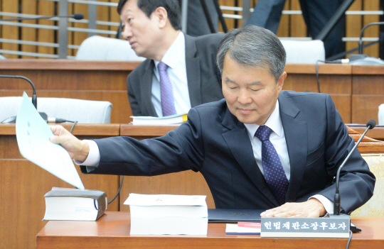 22일 오전 국회에서 열린 헌법재판소장 인사청문회에서 이진성 헌재소장 후보자가 책상 위에 놓인 서류를 정리하고 있다.