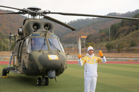 서기원 조종사가 21일 전남 진도군 공설운동장에서 2018 평창동계올림픽 성화를 들고 수리온 헬기 앞에서 포즈를 취하고 있다.