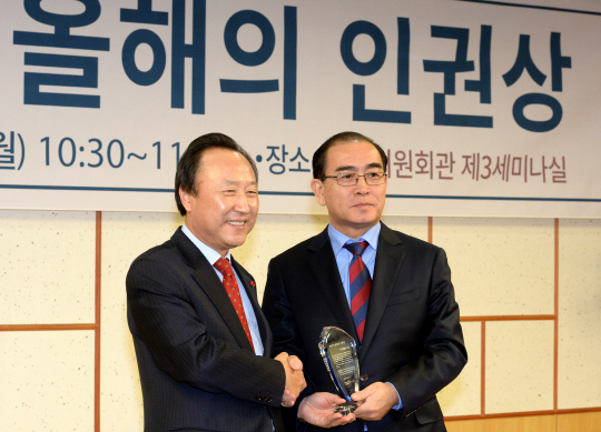국회인권포럼·아시아인권의원연맹의 ‘2017년 올해의 인권상’ 수상자로 선정된 태영호(오른쪽) 전 주영국 북한 공사가 11일 오전 국회 의원회관에서 열린 시상식에서 홍일표 자유한국당 의원에게서 상패를 받은 뒤 기념사진을 찍고 있다.  김호웅 기자 diverkim@