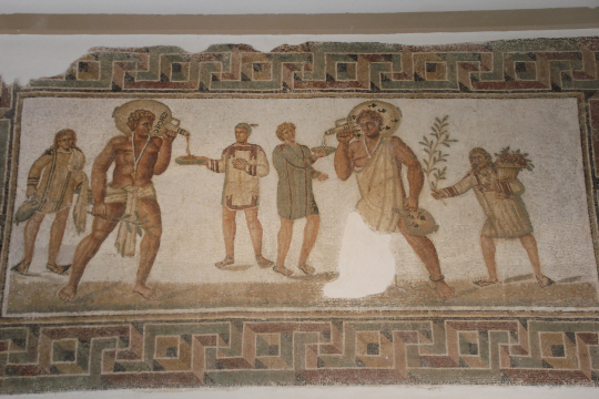 튀니지 바르도 박물관에 있는 3세기 로마 모자이크. 덩치 큰 노예가 짧은 투니카를 입은 손님의 잔에 피처에 담긴 술을 따르는 모습.