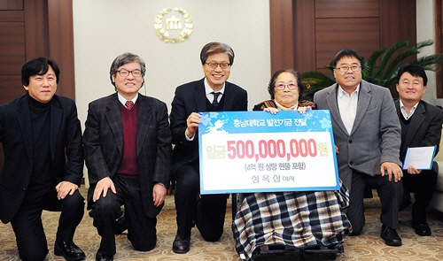 성옥심(오른쪽 세 번째) 할머니가 12일 충남대에 부동산과 현금 등 5억 원 상당의 발전기금을 낸 뒤 오덕성(〃네 번째) 총장 등과 기념촬영을 하고 있다.  충남대 제공, 연합뉴스