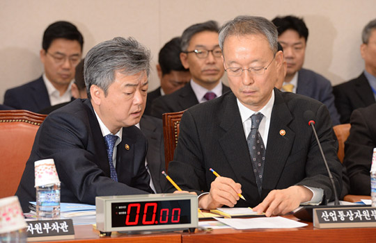 백운규(앞줄 오른쪽) 산업통상자원부 장관이 18일 오전 국회 산업통상자원중소벤처기업위원회 전체회의에 출석해 이인호 산업부 차관과 필담을 나누며 보고 내용을 가다듬고 있다.