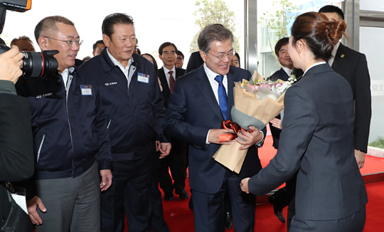 문재인 대통령이 정의선(왼쪽 첫 번째) 현대자동차 부회장의 안내로 16일(현지시간) 중국 충칭(重慶)시 량장신(兩江新)구에 위치한 현대차 충칭공장을 방문해 직원으로부터 환영 꽃다발을 받고 있다. 뉴시스