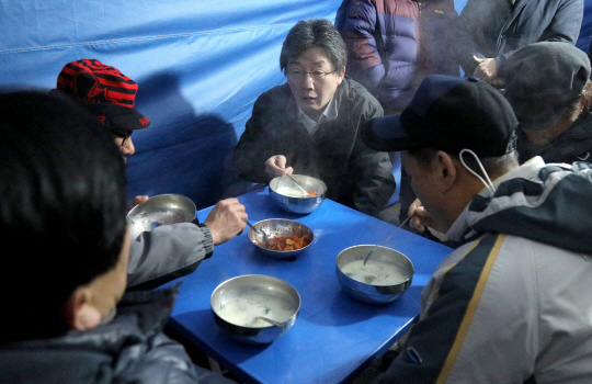 유승민 바른정당 대표가 21일 오전 서울 양천구 신정네거리 국민은행 앞에서 건설 일용 근로자들과 떡국을 먹으며 이야기를 하고 있다. 바른정당 제공
