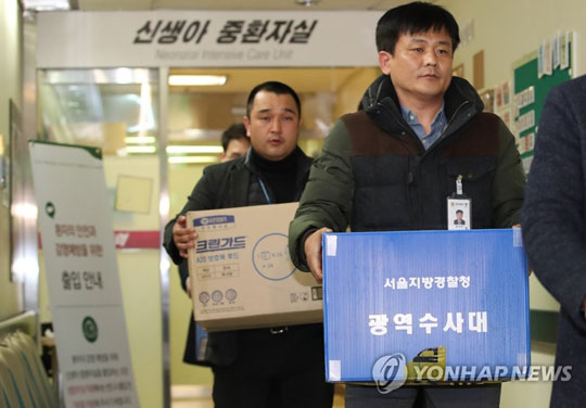 (서울=연합뉴스) 서울지방경찰청 광역수사대 관계자들이 19일 오후 서울 양천구 이대목동병원에서 신생아 사망사건 관련 압수수색을 마친 뒤 압수물품을 들고 신생아중환자실을 나서고 있다. 2017.12.19