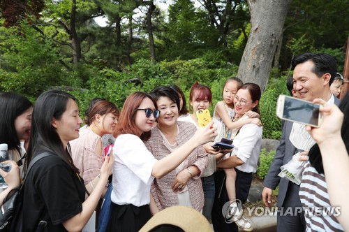 (서울=연합뉴스) 청와대는 31일 오전 한해를 결산하며 ‘2017년에 활짝 열린 청와대’ 라는 제목으로 김정숙 여사의 사진을 공개했다. 사진은 지난 6월 2일 청와대를 관람하는 시민들과 조우한 김정숙여사가 기념사진을 촬영하는 모습. 2017.12.31 [청와대 제공=연합뉴스]