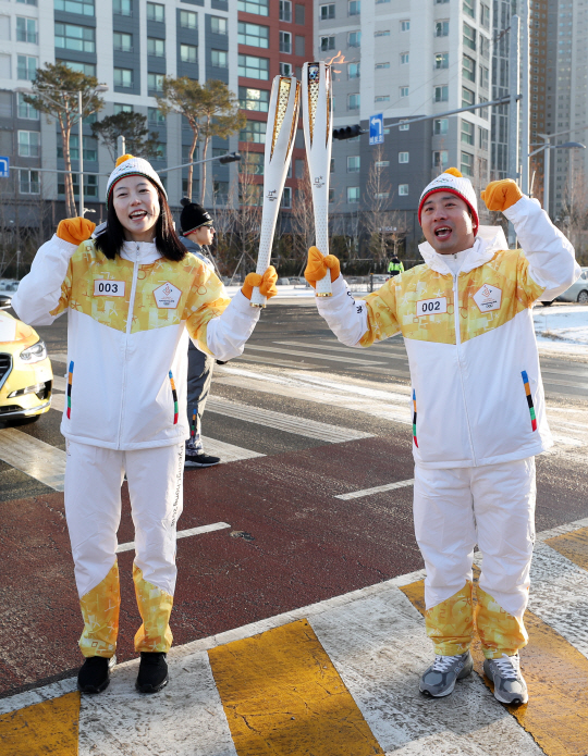 삼성전기 배드민턴선수단의 김하나(왼쪽)와 정재성 코치가 10일 오전 인천 연수구 송도에서 열린 2018 평창동계올림픽 성화 봉송 행사에서 성화를 주고받고 있다.