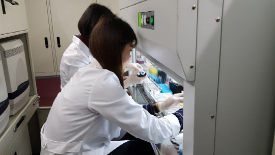 15일 강원 강릉시 선수촌로 선수촌식당에 배치된 신속유전자검사 차량에서 식품의약품안전처 연구원이 음식에 대한 세균검사를 진행하고 있다.