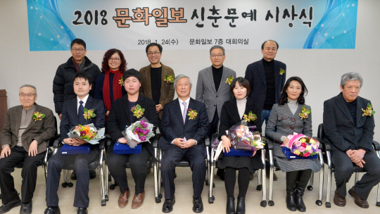 2018 문화일보 신춘문예 당선자 4명과 심사위원들이 24일 오후 서울 중구 새문안로 문화일보사 7층 대회의실에서 열린 시상식 후 기념 촬영을 하고 있다. 앞줄 왼쪽부터 황동규 시인, 김용준(동화), 송민우(문학평론), 이병규 문화일보 회장, 박은영(시), 이경란(단편소설), 김원우 소설가. 뒷줄 오른쪽부터 구효서 소설가, 정호승 시인, 서영채 문학평론가, 김서정 동화작가, 문태준 시인. 김낙중 기자 sanjoong@
