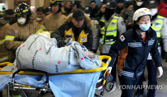 (서울=연합뉴스) 화재로 대형참사가 발생한 26일 오전 경남 밀양 세종병원 현장에서 대한적십자 봉사자와 소방대원들이 환자를 긴급 이송하고 있다. [대한적십자 제공=연합뉴스]