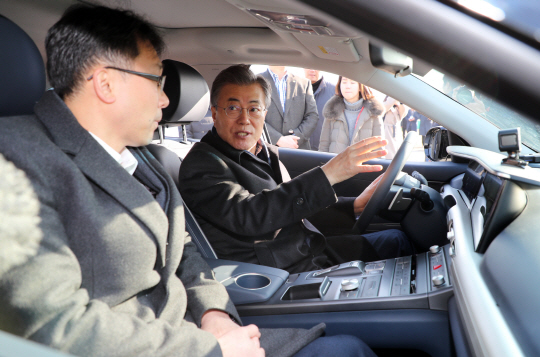문재인 대통령이 2일 오전 자율주행차 시승장인 서초구 만남의 광장 휴게소에서 신형 자율주행 수소차인 ‘넥쏘’에 올라 현대자동차 자율주행차 개발팀장 이진우 상무의 설명을 듣고 있다.  연합뉴스