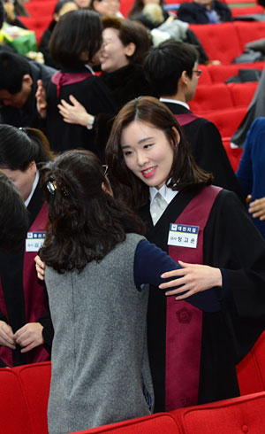 5일 오전 경기 과천 법무부청사에서 열린 임관식에서 신임 검사들이 가족들의 도움을 받아 법복을 입고 있다.