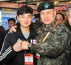 지난 1월 25일 부산 벡스코에서 열린 ‘드론쇼 코리아’ 육군 홍보부스에 초청받은 김민찬(왼쪽)군이 김용우 육군참모총장과 주먹을 맞대고 인사하고 있다.  연합뉴스