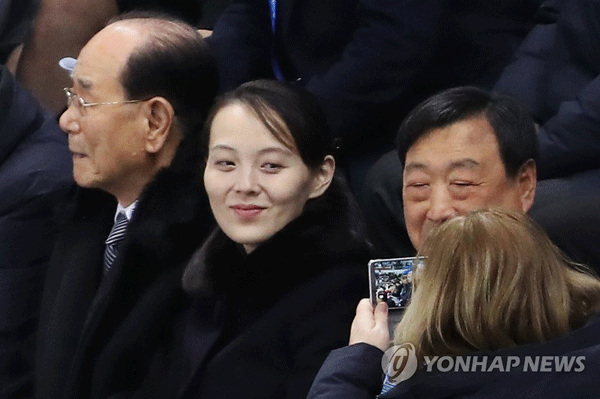 (강릉=연합뉴스) 북한 김정은 국무위원장의 특사 자격으로 방남한 김여정 중앙위원회 제1부부장이 10일 강원도 강릉 관동하키센터에서 열린 2018 평창동계올림픽 여자 아이스하키 B조 조별리그 1차전 남북단일팀과 스위스의 경기에서 한 참석자의 사진 촬영에 미소를 짓고 있다. 왼쪽은 북한 김영남 최고인민회의 상임위원장, 오른쪽은 이희범 평창동계올림픽 조직위원장. 2018.2.10
