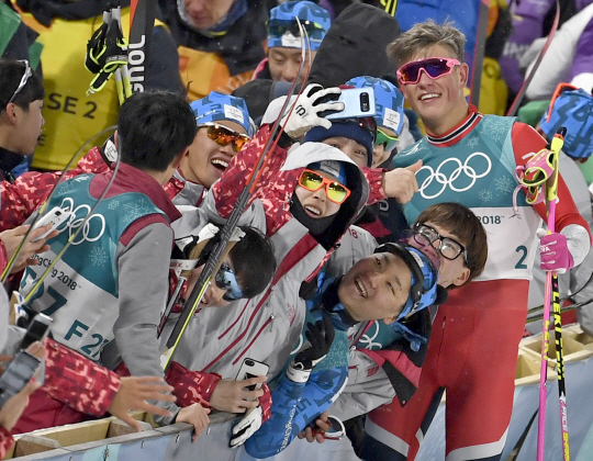 노르웨이의 요하너스 후스플로트 클라에보(오른쪽)가 13일 평창 알펜시아크로스컨트리센터에서 열린 2018 평창동계올림픽 크로스컨트리스키 남자 스프린트 클래식에서 우승한 뒤 관중, 자원봉사자들과 기념촬영을 하고 있다.  EPA 연합뉴스