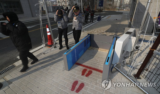 (강릉=연합뉴스) 강풍특보가 내린 14일 오후 강릉 미디어빌리지의 한 검색대가 바람에 쓰러져 있다. 안전요원은 육안으로 AD카드를 확인했다.