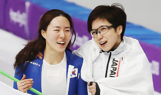 이상화(스포츠토토·왼쪽)와 일본의 고다이라 나오가 18일 밤 강릉스피드스케이팅경기장에서 열린 2018 평창동계올림픽 스피드스케이팅 여자 500m 레이스를 마친 뒤 어깨동무를 한 채 밝은 표정으로 이야기를 주고받고 있다.  연합뉴스