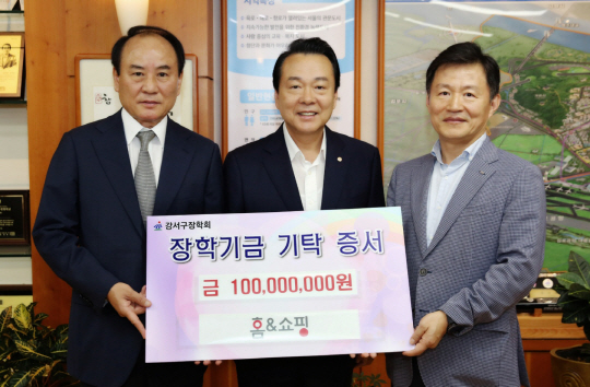 강남훈(오른쪽) 홈앤쇼핑 대표가 지난해 9월 서울 강서구청에서 송진수(왼쪽) 강서구장학회장에게 장학금을 기탁하고 있다.  홈앤쇼핑 제공