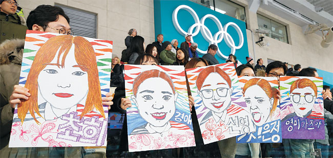 25일 강릉컬링센터에서 열린 2018 평창동계올림픽 여자컬링 결승전에서 관중들이 한국 대표팀 김초희, 김경애, 김선영, 김은정, 김영미(이상 경북체육회) 등의 캐리커처를 들고 응원전을 펼치고 있다.  연합뉴스