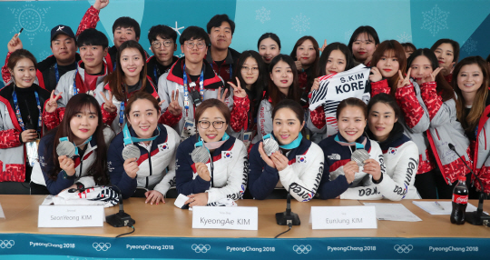 컬링 여자대표팀의 김민정(앞줄 오른쪽부터) 감독과 김은정, 김경애, 김선영, 김영미, 김초희가 25일 강릉컬링센터에서 열린 스웨덴과의 결승전을 마친 뒤 은메달을 목에 걸고 자원봉사자와 기념 촬영을 하고 있다.  연합뉴스