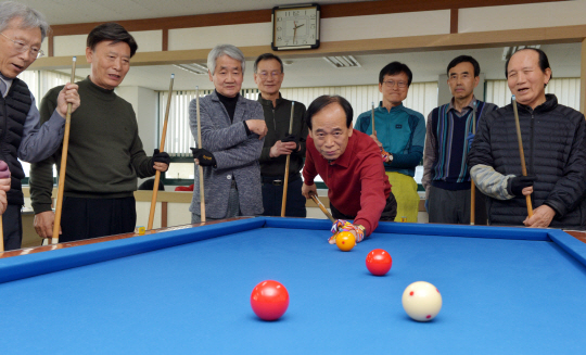 지난 14일 오후 부산 부산진구 양정동 부산시 행정동우회 건물의 당구대에서 당구동호회의 배남규(69·맨 왼쪽) 회장, 차철규(80·맨 오른쪽 ) 고문 등이 지켜보는 가운데 신영수(73) 회원이 4구를 치기 위해 자세를 취하고 있다. 60대 중반부터 80대 초반까지 공무원 퇴직자들로 구성된 이들은 매주 두 번의 당구 모임으로 건강과 활력을 유지하고 있다.  부산 = 김낙중 기자 sanjoong@