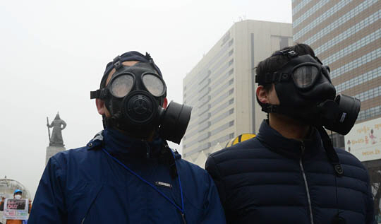 미세먼지 비상저감조치에 들어간 26일 오전 서울 광화문 거리에서 녹색서울시민위원회 회원 등이 방독면을 쓰고 미세먼지 줄이기 캠페인을 벌이고 있다.