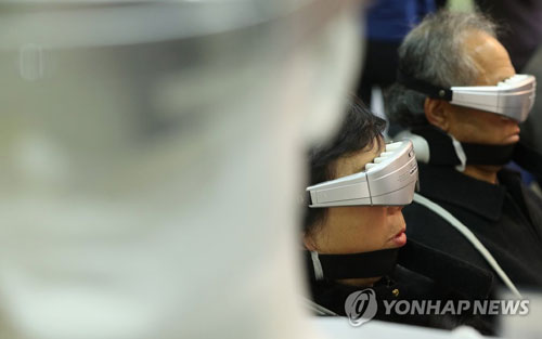 치료기 체험하는 노인 [연합뉴스 자료사진]