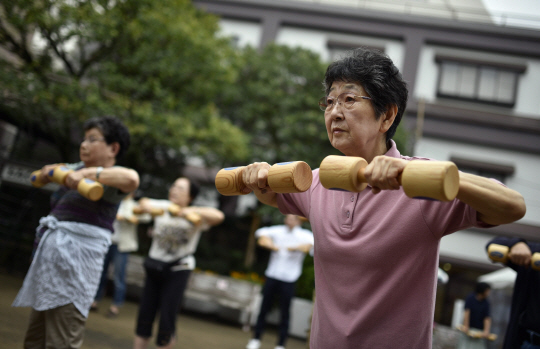 일본 노인들이 9월 셋째 월요일 경로의 날을 맞아 도쿄 한 공원에서 함께 모여 나무 덤벨을 갖고 운동하고 있다.  자료사진