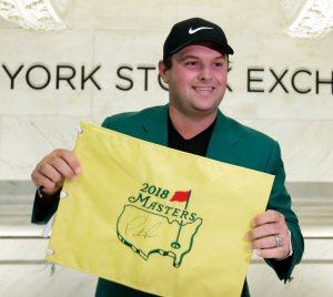 미국프로골프(PGA)투어 마스터스에서 우승한 미국의 패트릭 리드가 10일 오전(한국시간) 미국 뉴욕 증권거래소를 방문, 자신이 사인한 마스터스 핀 깃발과 함께 포즈를 취하고 있다.  AP 연합뉴스