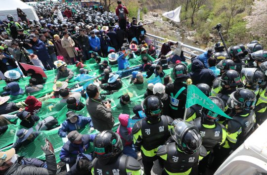12일 오전 경찰이 경북 성주군 고고도미사일방어체계(THAAD·사드) 기지 앞 진밭교 위에 알루미늄 파이프로 격자 틀을 만들고 그물을 감싼 채 연좌 농성을 하는 사드 반대 단체 회원과 일부 주민들을 한 명씩 끌어내는 해산 작전을 벌이고 있다.  연합뉴스