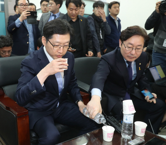 김경수(왼쪽) 더불어민주당 의원이 16일 여의도 국회 정론관에서 ‘민주당원 댓글조작 사건’과 관련 기자회견을 마친 뒤 물을 마시고 있다.