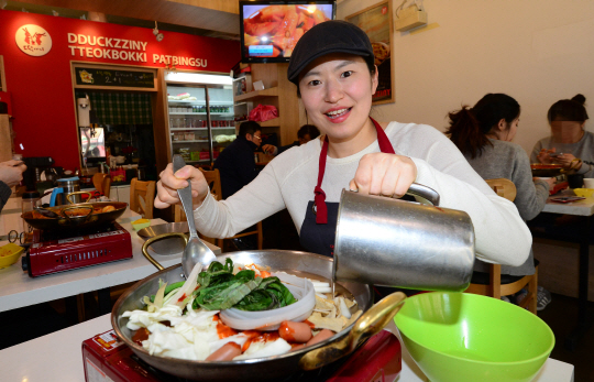 ㈜떡찌니의 석지현 대표가 18일 서울 강남구 도곡동 떡찌니 매장에서 직접 떡볶이 조리를 하고 있다.