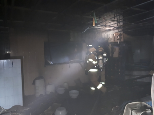 소방대원이 불탄 목욕탕에서 인명 검색하고 있다. [부산남부소방서 제공=연합뉴스]