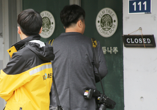‘민주당원 댓글조작 사건’을 수사 중인 경찰이 22일 ‘드루킹’ 김동원(49·구속 기소) 씨가 운영하던 경기 파주시의 느릅나무 출판사를 압수 수색한 가운데 취재진이 출판사 사무실 안을 들여다보고 있다.  연합뉴스
